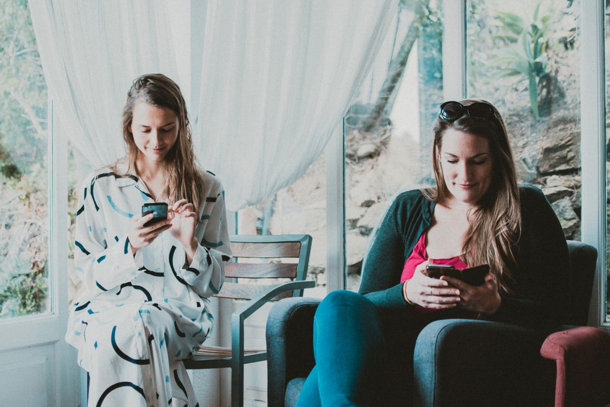 People using a phone or laptop at home